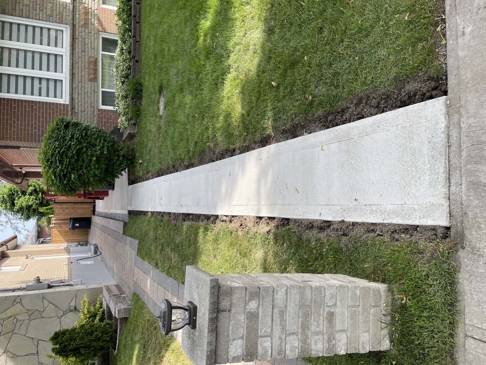 New concrete sidewalk after replacement between Toronto houses