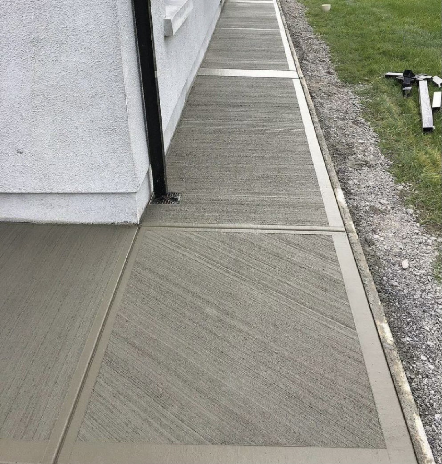 Concrete sidewalk along a Toronto house wall