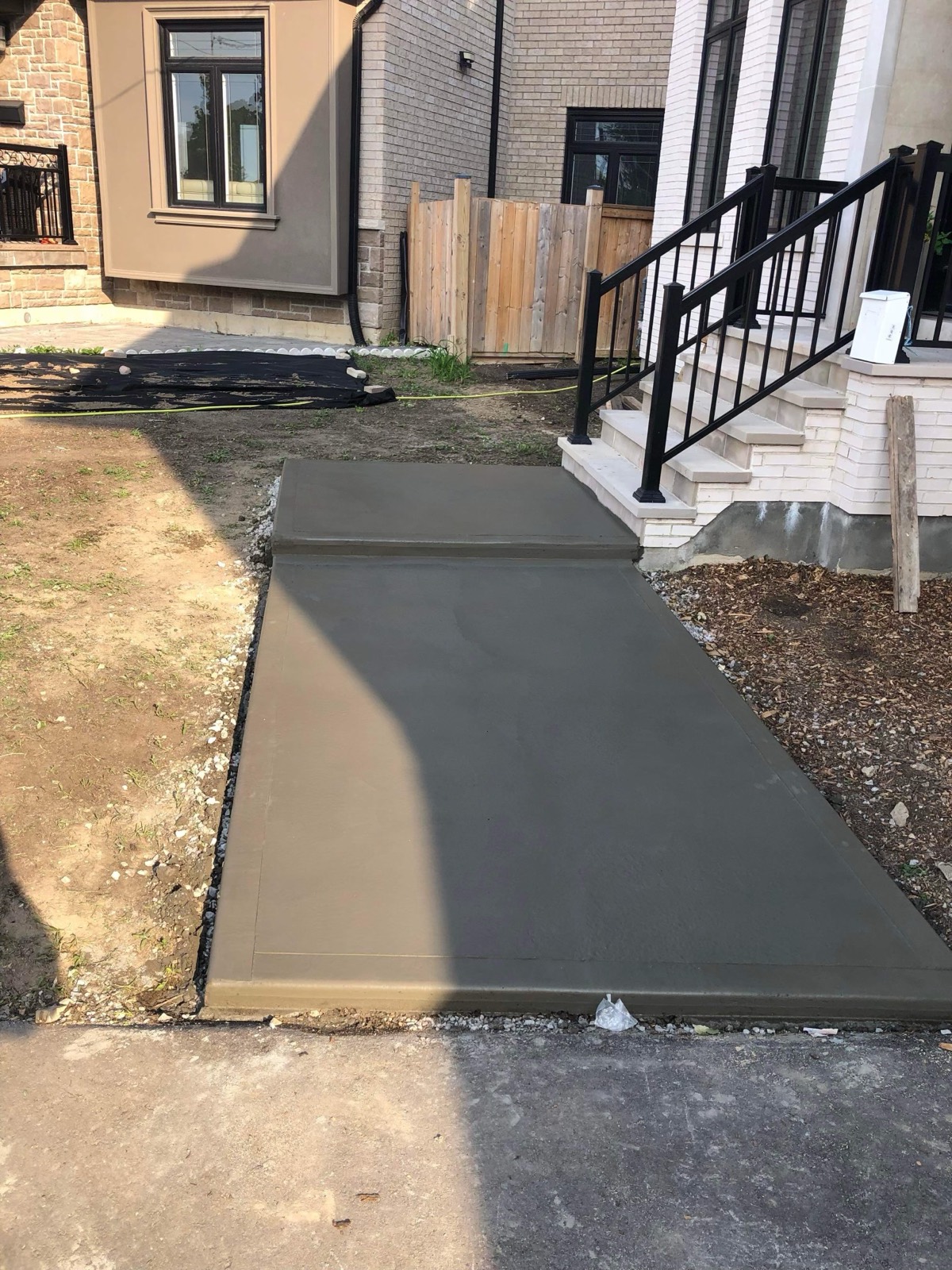 New concrete walkway meeting porch steps at a Toronto home